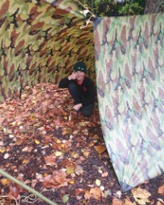 a child in a camouflaged shelter